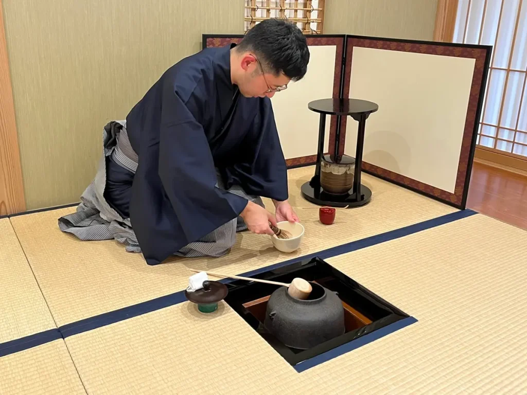 A tea practitioner preparing matcha in a Japanese-style room in Tokyo.