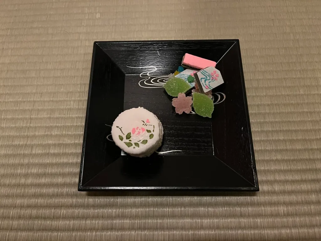 Traditional Japanese dry sweets arranged on a black lacquer tray.